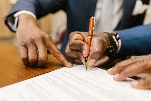 man pointing to spot on paper
